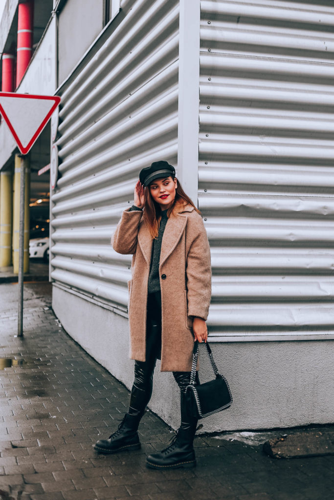 Blogger wearing overcoat and combat boots.