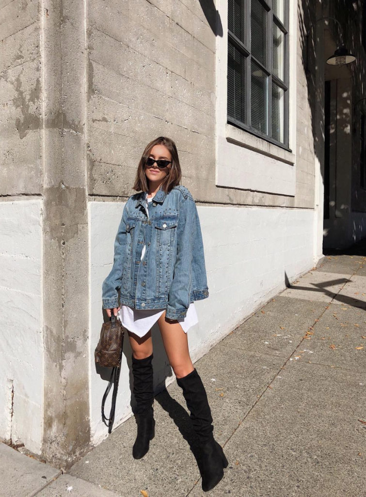 Blogger wearing denim jacket and knee high boots.