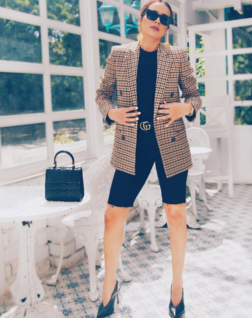 Woman pairing shorts with patterned blazer.