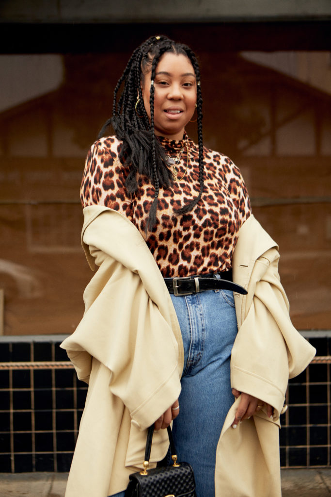 Posing in a leopard top and brown coat.