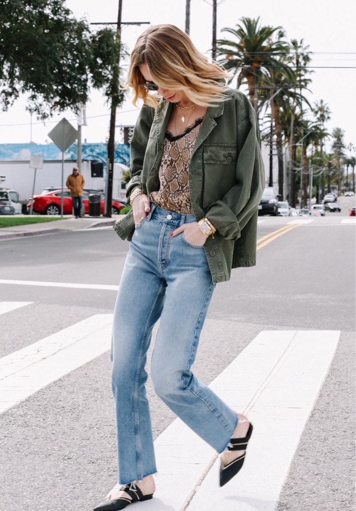 Blogger wearing light jeans and olive jacket.