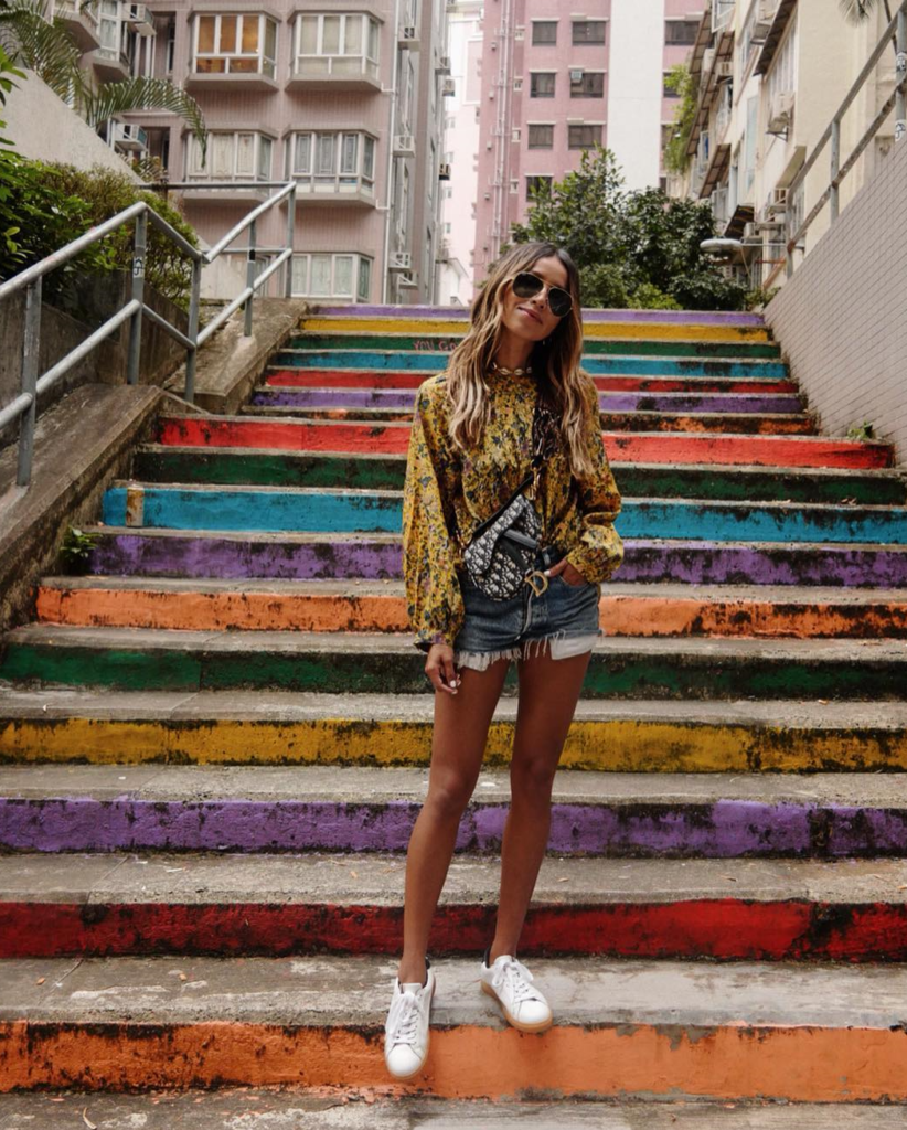 Blogger wearing overall shorts on stairs.