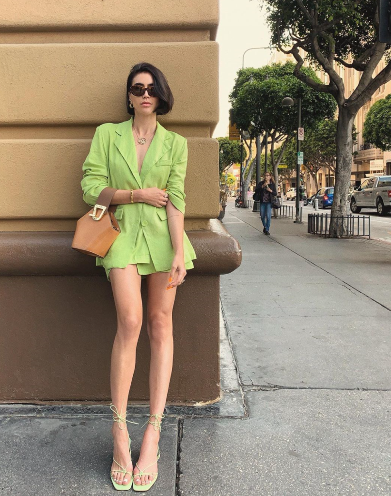 Woman pairing bright suit with flip flops.