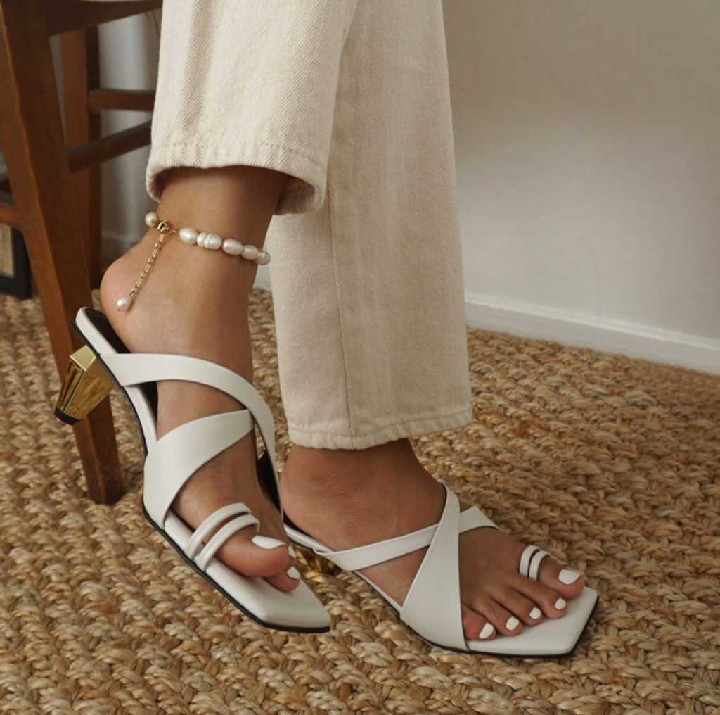 Woman highlighting summer trends with anklet and small heeled shoes.
