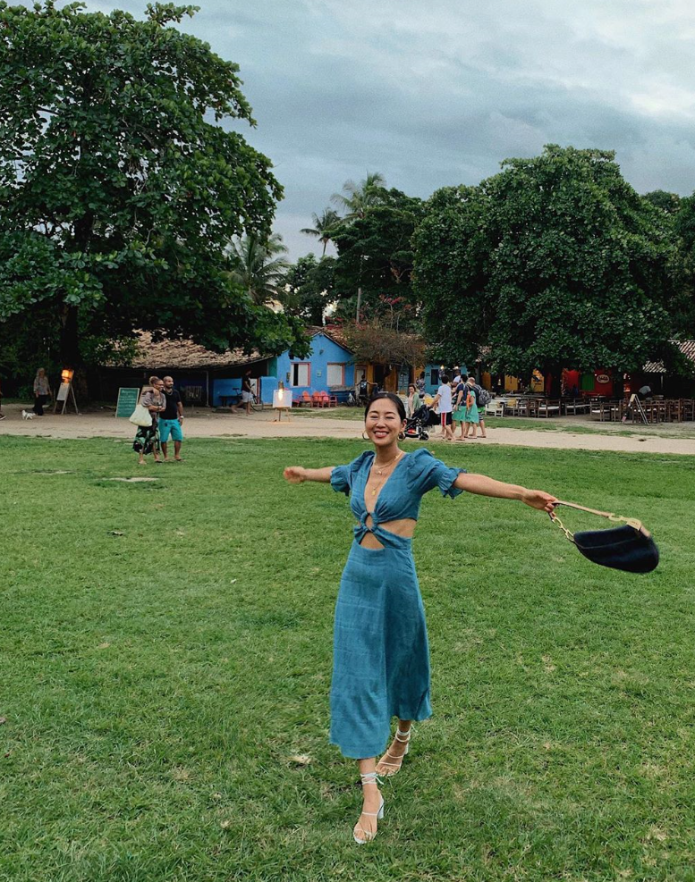Woman wearing a full blue jumpsuit in a park.