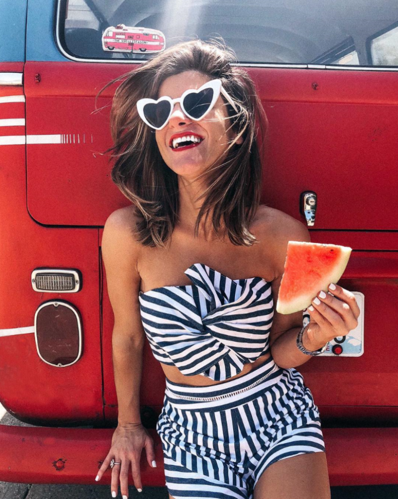Woman in two-piece striped blue set on red truck.