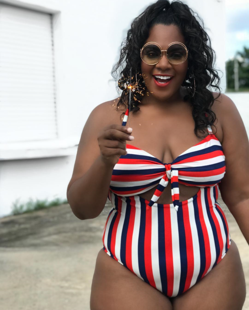 Woman wearing striped swimsuit for 4th of July.