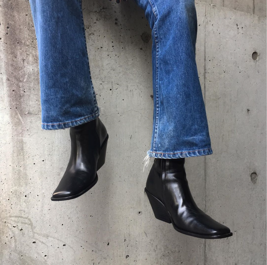 Cropped photo of black square-toed boots with denim as an option for fall styles.