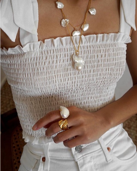 Woman wearing pearl accessories that remind us of the beach.