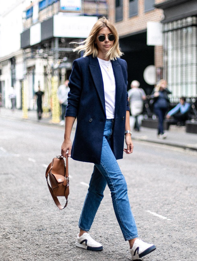 Woman adding white tee to jeans and blazer for a Labor Day idea.