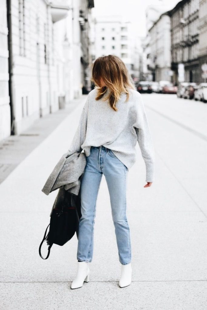 Woman wearing white ankle booties with denim.