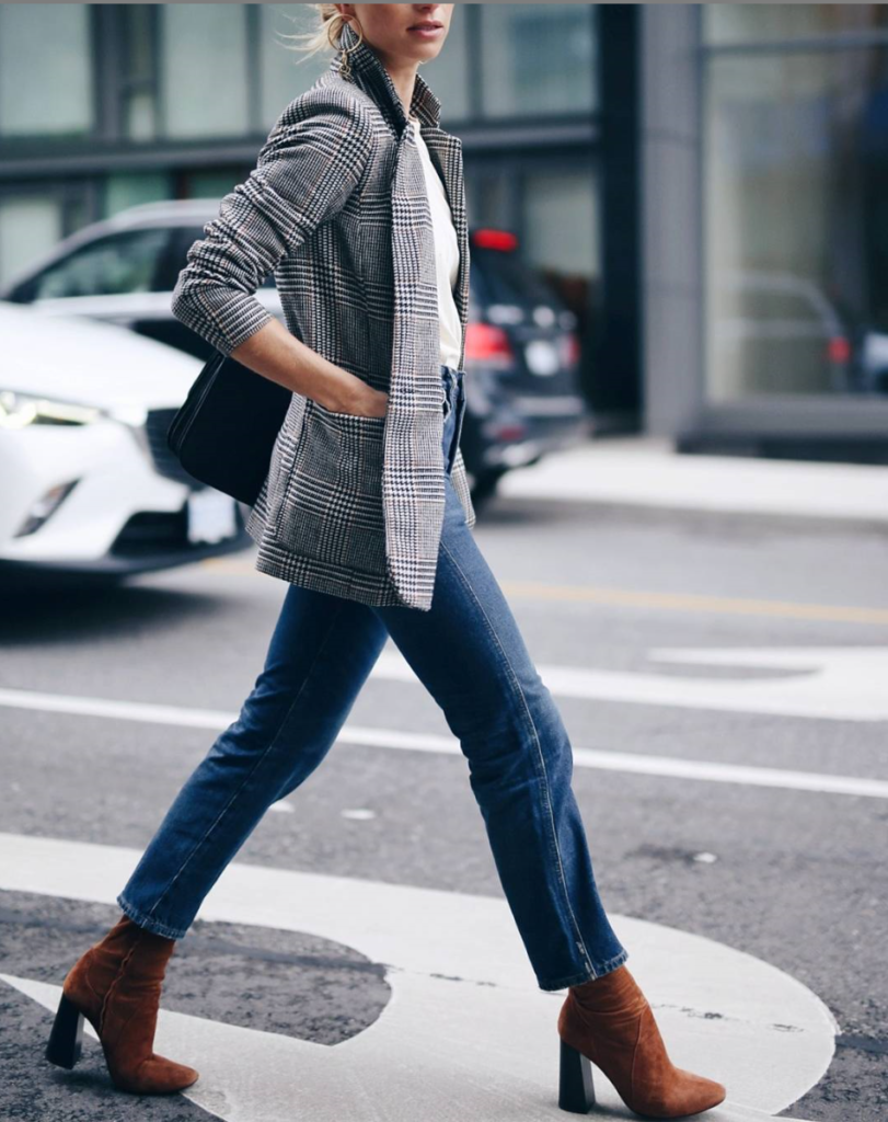 Woman wearing denim bootcut jeans with a blazer for fall.