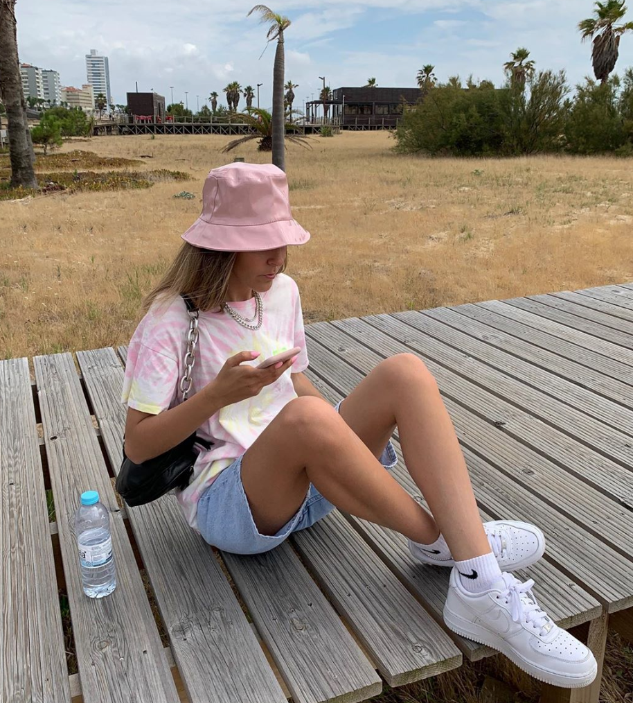 Woman sitting outside with a pastel hat.
