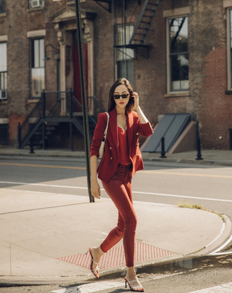 Woman walking the street wearing shades of burgundy for NYFW.
