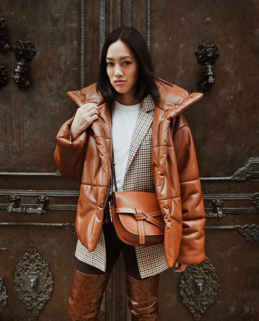 woman wearing cognac colored puffy outerwear with matching purse.