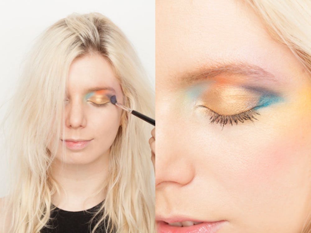 Makeup artist wearing multicolored eye shadow makeup.
