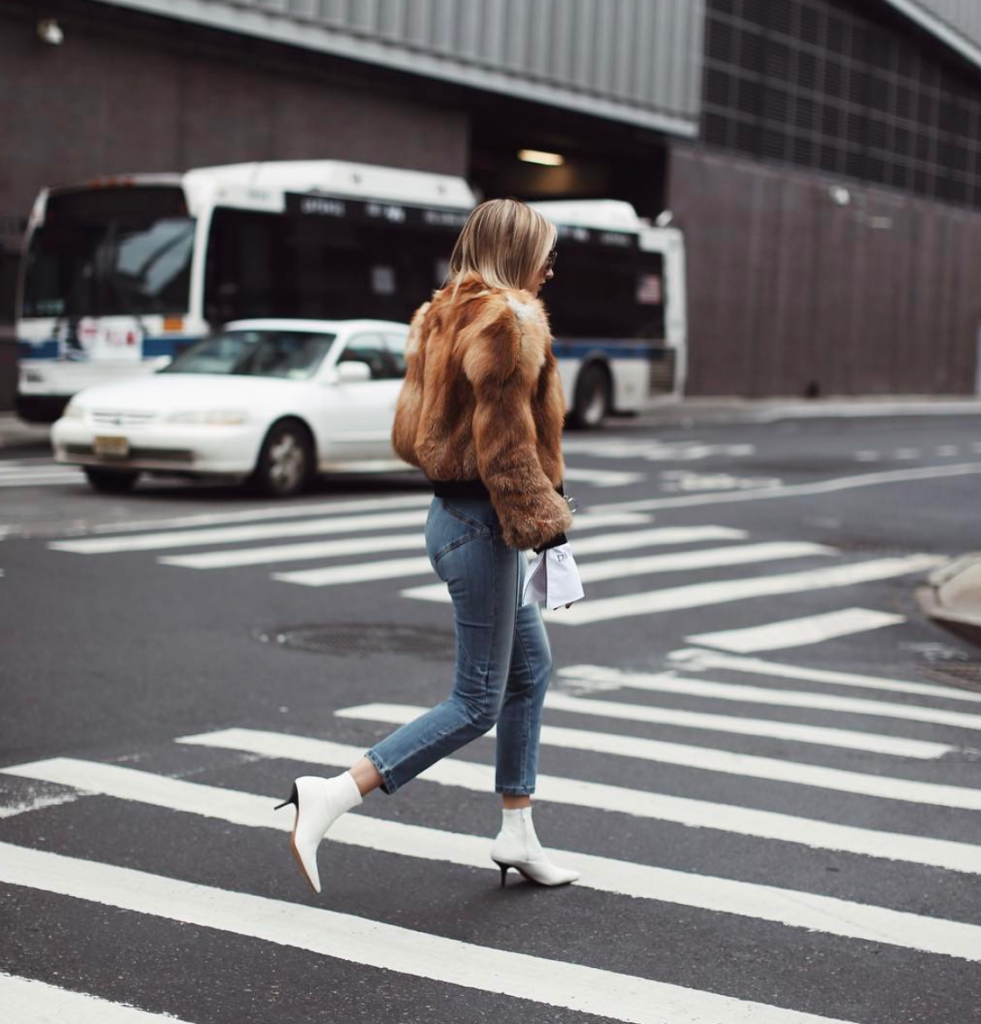 Woman in a crosswalk wearing a pointed boot.
