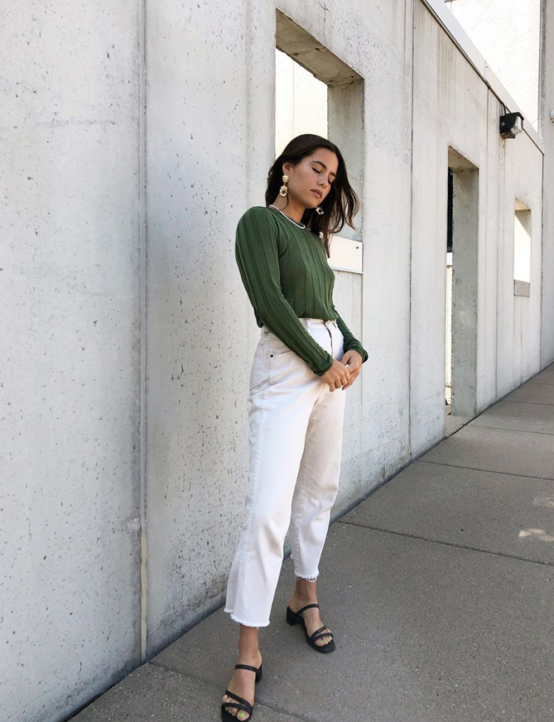 Woman wearing white jeans and sweater for fall transitional style.