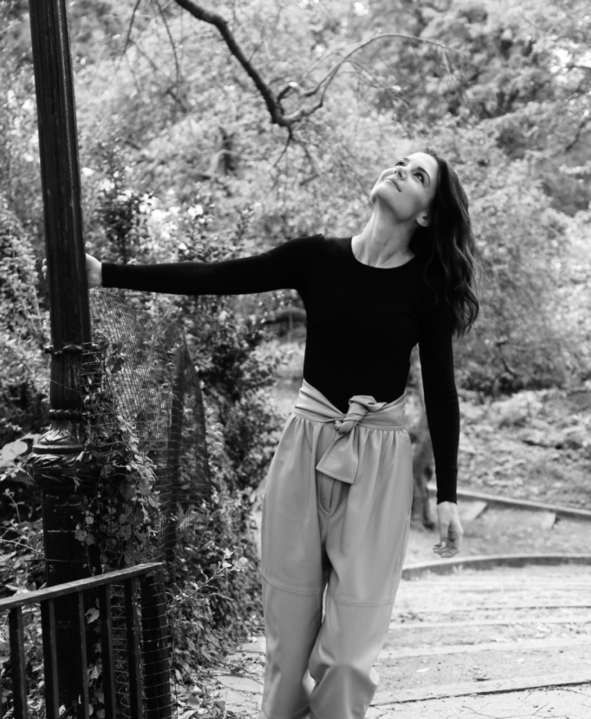 Photo of Katie Holmes in knotted trousers and black top.