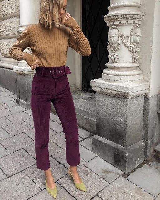 Woman wearing amethyst jewel tone pants with brown sweater.