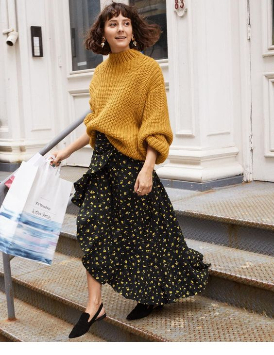 Blogger pairing patterned skirt with oversized sweater.