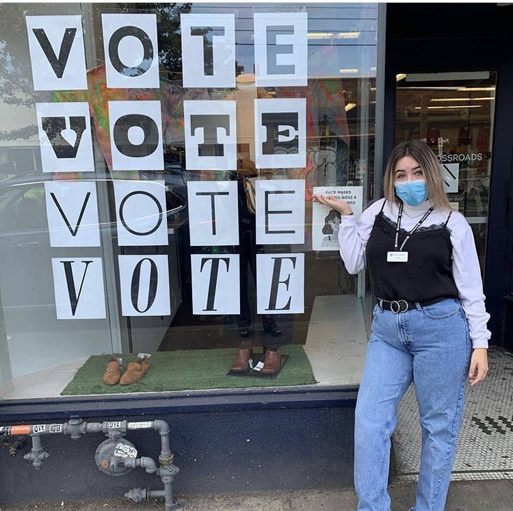 Photo of employee in front of vote sign