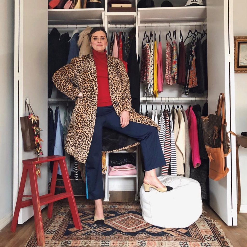 photo of woman in closet who plans to spring clean and sell clothes this weekend