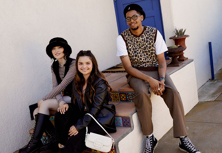 Bryce, Julia and Maddy sitting on the stairs outside wearing fall fashion.