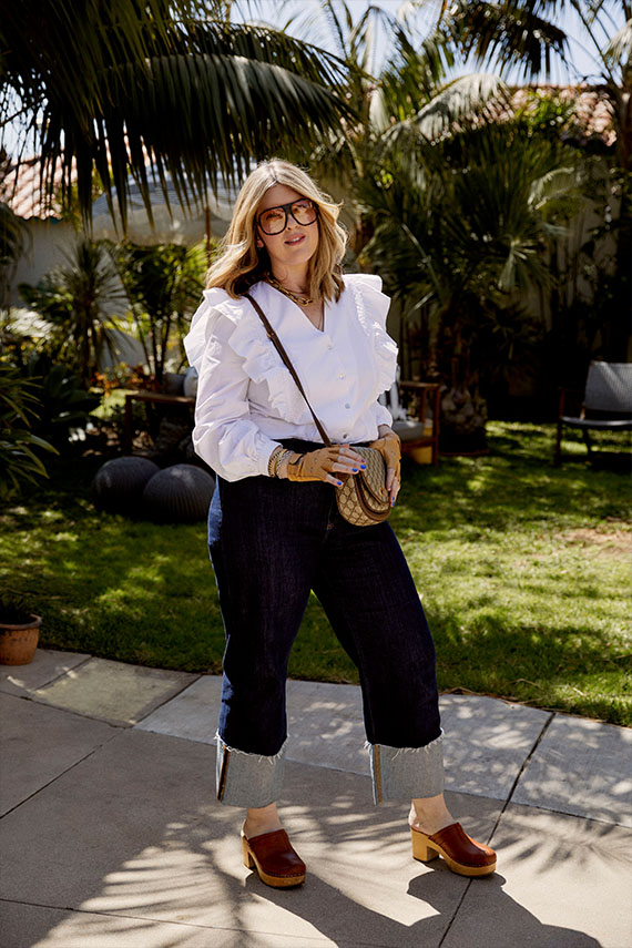 Christie wearing a white blouse, gucci purse and dark blue jeans