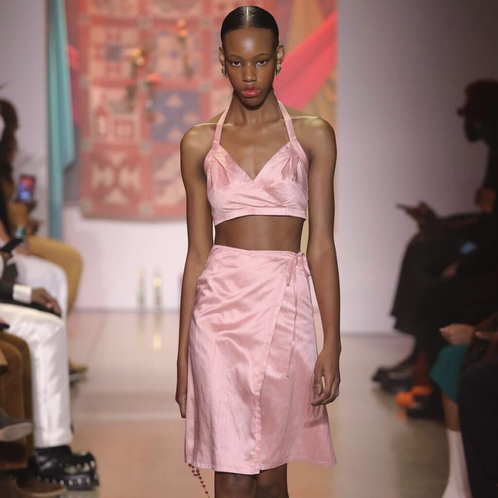 photo of model on runway in pink outfit