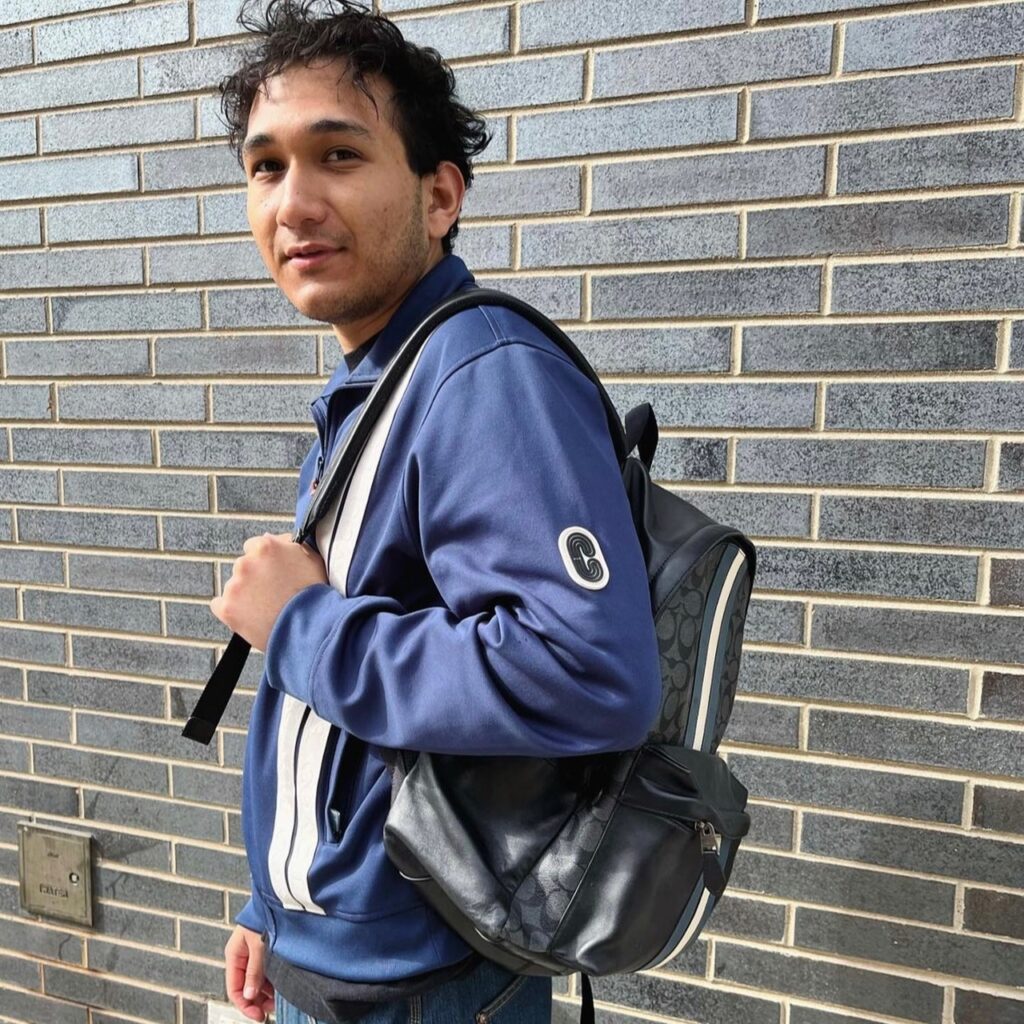 photo of person wearing Coach jacket and backpack