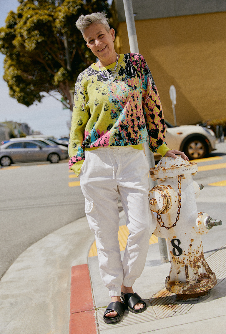 Model wearing summer clothing standing next to a fire hydrant