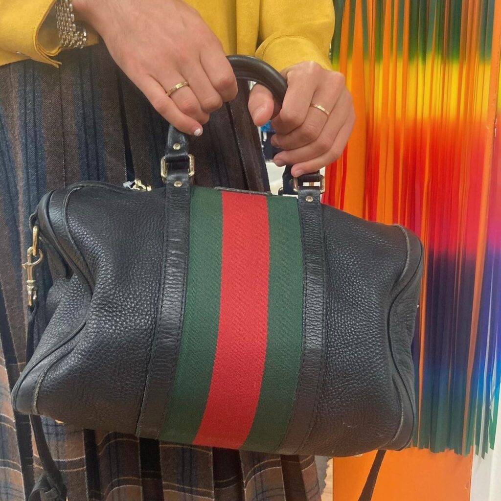 photo of a black leather Gucci handbag with classic Gucci striping