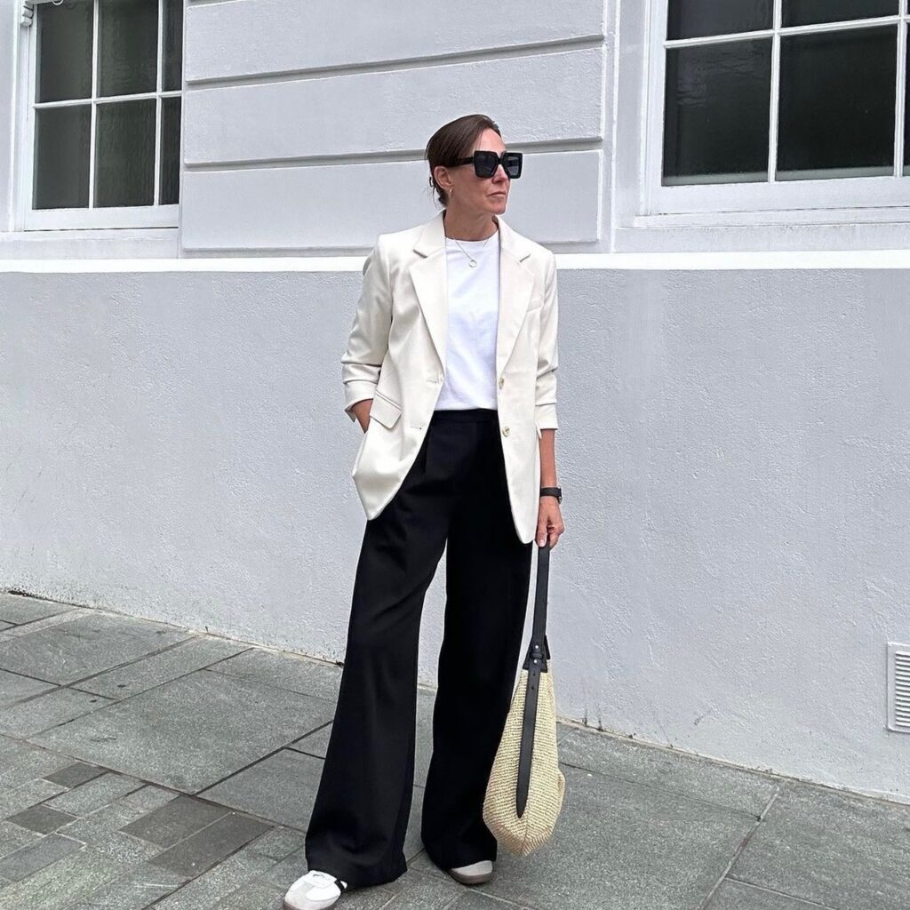 photo of person in wide leg black trousers with white t-shirt and beige blazer