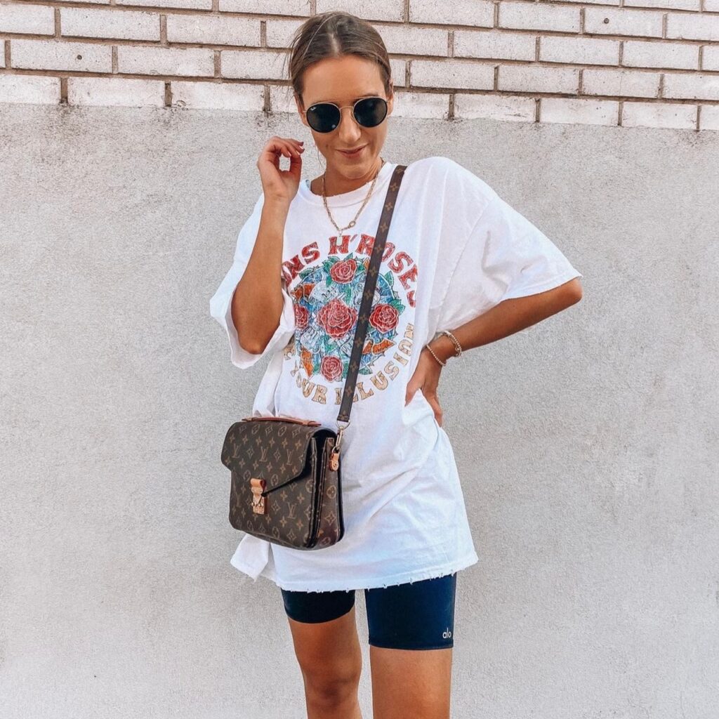 woman with sunglasses, oversized graphic tee, and biker shorts