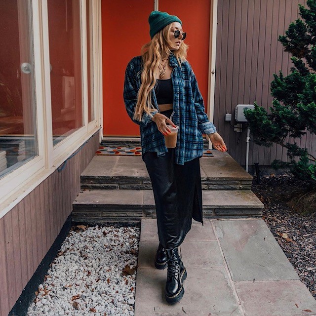 woman wearing flannel shirt with tank top, skirt, and boots