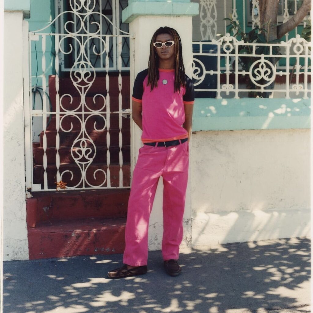 man wearing sunglasses with a hot pink outfit