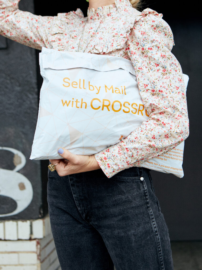 woman holding a Crossroads Sell by Mail bag