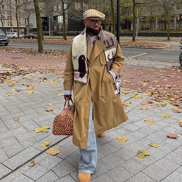 man in jeans, trench coat, cap, and thick wool scarf