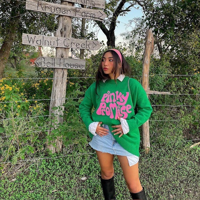 girl in micro mini skirt with green sweatshirt and tall boots