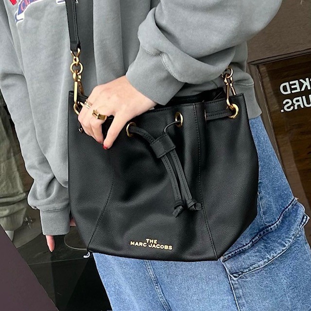 A black drawstring bucket bag, an example of popular 90's purses