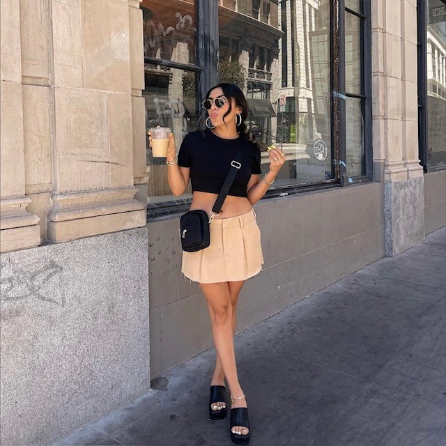 girl in tan micro mini skirt with black cropped top and platform sandals
