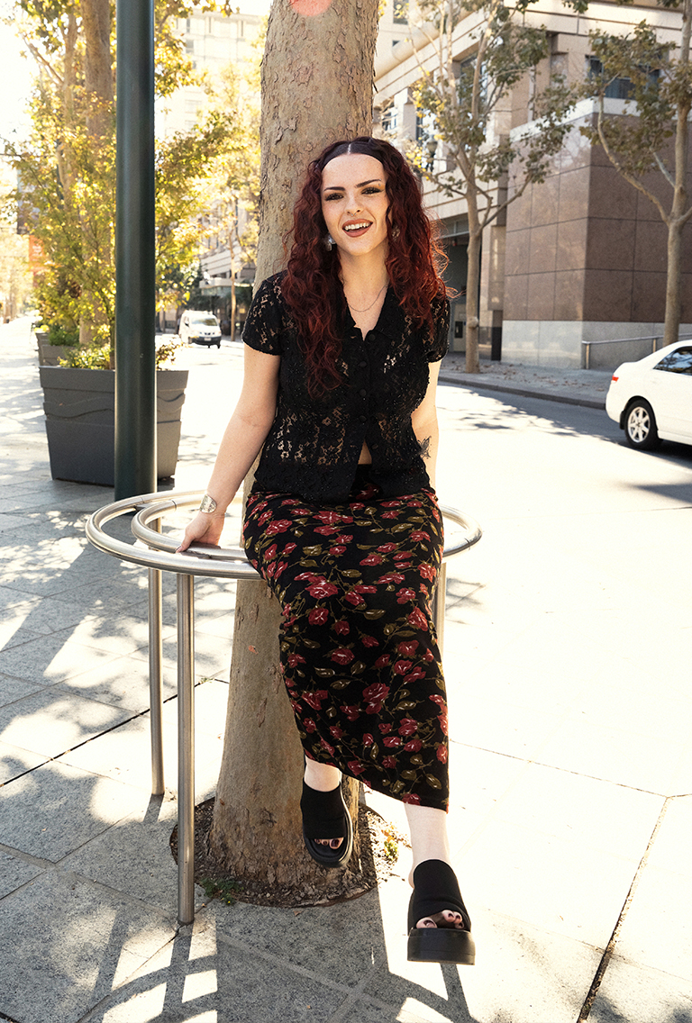 model wearing a black lace shirt and a floral skirt