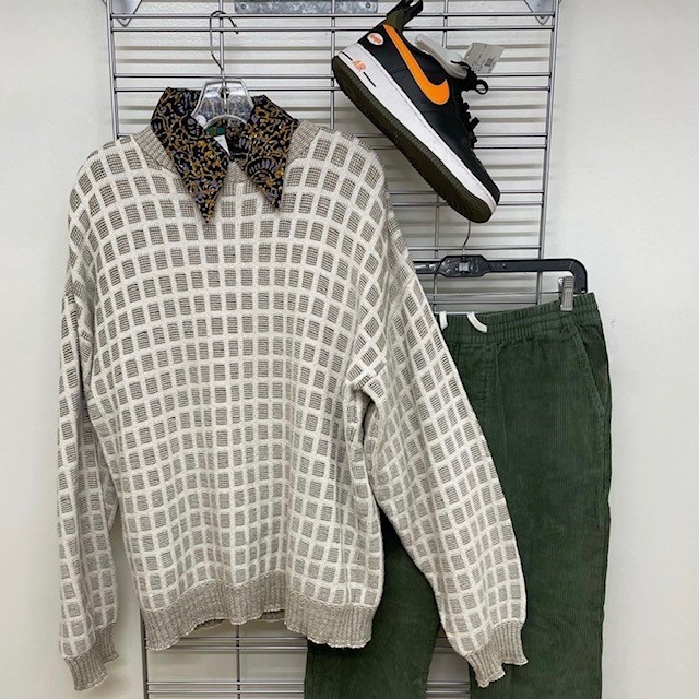 example of pre-loved clothes: a checked sweater, pair of sneakers, and green corduroy pants