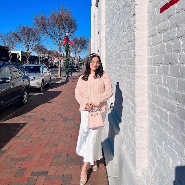 woman with pink sweater, maxi skirt, and pink shoes