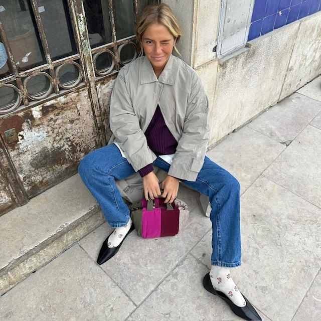 woman with black ballet flats, jeans, sweater, and jacket