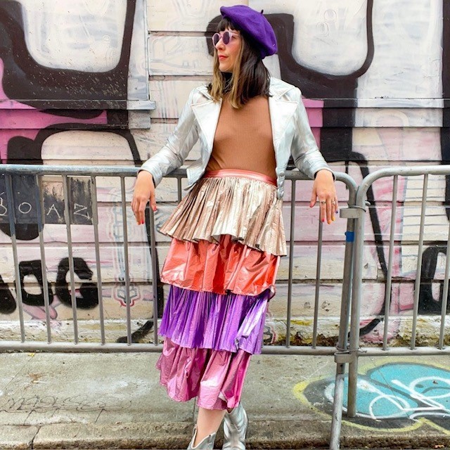 woman wearing a metallic fashion skirt in lame with ruffles in gold, red, purple, and pink
