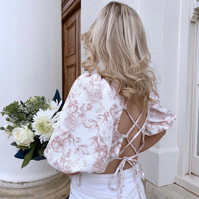 woman showing back of toile lace up top