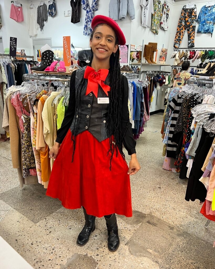 a retail employee in a red and black outfit