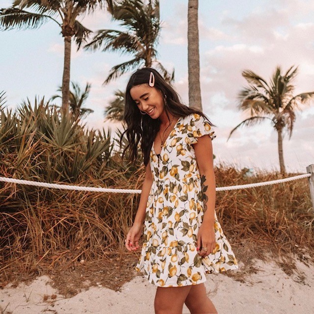 woman walking on beach with a lemon print babydoll dress